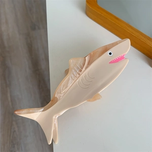 Detailed macro of medium acetate shark hair claw clip with marble pattern and pink accents