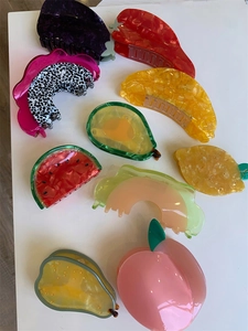 Détails macro de diverses pinces à cheveux en acétate en forme de fruits et de légumes