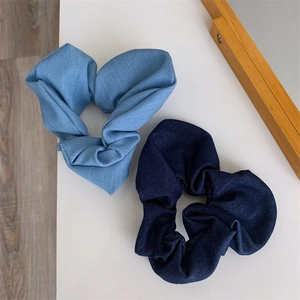 Detail of two-piece set blue denim fabric scrunchies with pleated design for hair styling