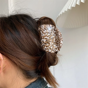 Elegant tortoiseshell acetate seashell hair claw clip shown on brunette hair