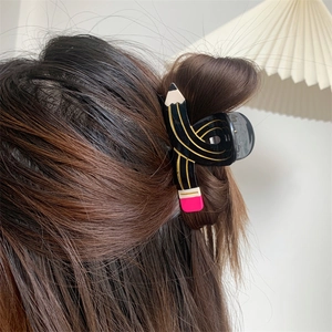 Detail of creative pencil-shaped hair claw clip styling for short hair updos