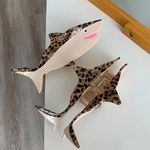Detail view of acetate shark claw clips with leopard print and cream color block design