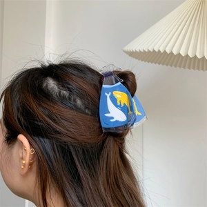 Creative transparent fish bag hair claw clip with yellow whale pattern on brunette hair