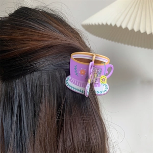 Detail of floral purple cup hair claw clip styled on dark brown hair in cozy setting