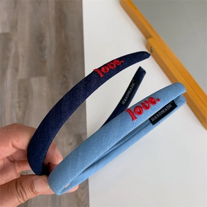 Detail of denim headband with red love embroidery and handmade inner label tag