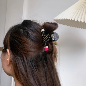 Detail shot of a black acetate hair claw clip in a creative pencil shape for long hair