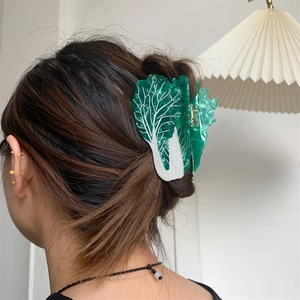 Detailed view of a creative cabbage-shaped acetate hair claw clip worn on a bun