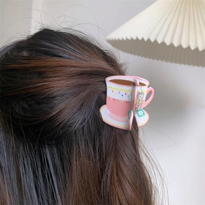 Close-up of a pink tea cup shaped hair claw clip styled on a model's hair