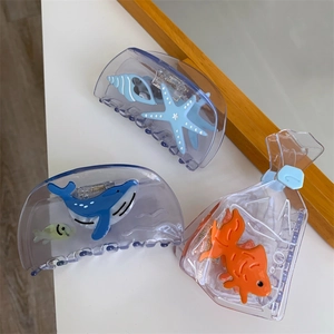 Detail view of ocean-themed acetate hair claws featuring starfish, whales and goldfish
