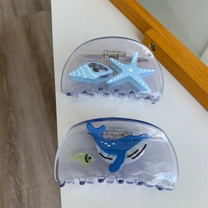Detail view of two sea-themed hair claws featuring starfish and whale designs