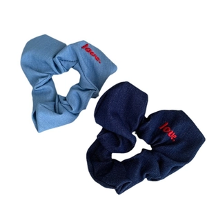 Blue denim fabric scrunchies with red love embroidery on a plain white background