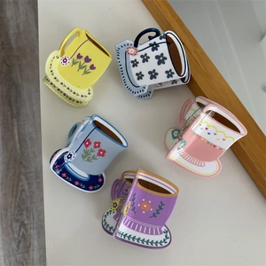 Detail showing five floral teacup shaped acrylic hair claws in assorted pastel colors