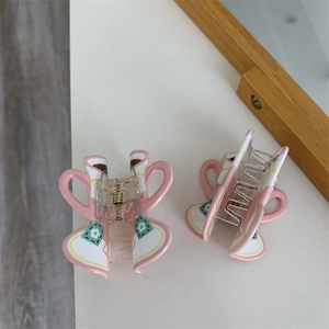 Detailed view of creative coffee cup hair claws with floral patterns and gold spring