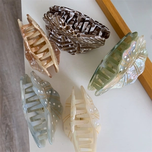 Detailed top view of five leaf-shaped acetate hair claws in various elegant pastel colors