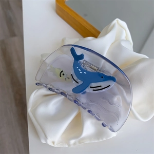 Detail of whale pattern on translucent blue acetate hair claw clip with ocean theme