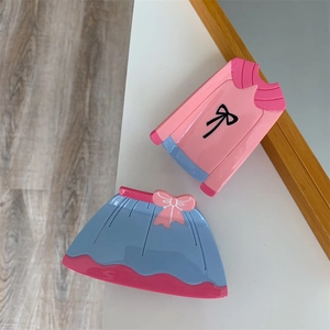 Détail des pinces à cheveux en forme de chemise rose et jupe bleue avec nœuds