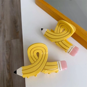 Detailed close-up of a creative pencil-shaped hair claw clip with a glossy resin finish