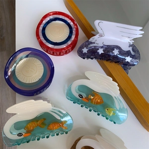 Dreamy acetate hair claws featuring unique swan, sun, and winged rabbit creative designs