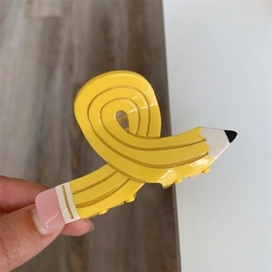 Creative yellow pencil shaped hair claw clip with pink eraser detail and glossy finish