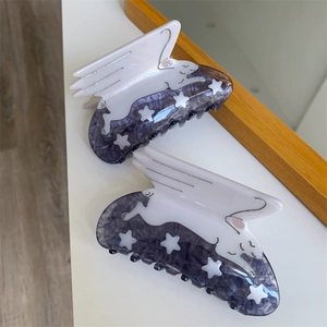 Detail of cartoon cat hair claw clips with purple marble pattern and star accents