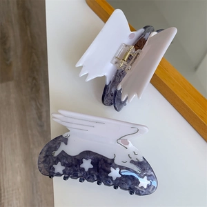 Detail of purple acetate hair claw with white rabbit design and star patterns