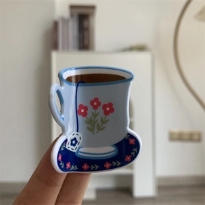 Detailed view of a light blue acrylic hair claw clip in a floral tea cup shape