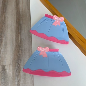 Vue détaillée de pinces à cheveux en forme de robe bleue avec nœud rose et bordure