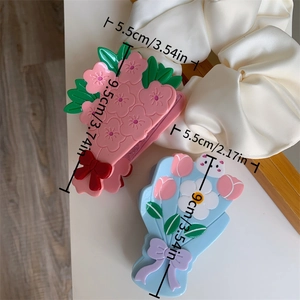 Détail des pinces à cheveux florales en acétate avec nœuds, montrant dimensions et texture