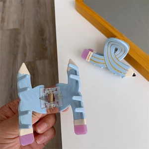 Detailed macro view of creative pencil shaped blue acetate hair claw clips for styling