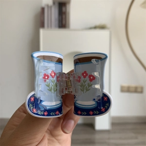 Detailed view of floral light blue rain boot shaped acrylic hair claw with metal spring