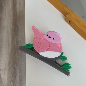 Vue détaillée d'une pince à cheveux créative en forme d'oiseau avec feuilles en acétate