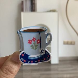 Close-up of floral acrylic coffee cup charm accessory held by hand for DIY hair clip crafts