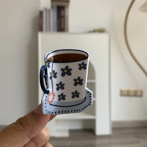 Close-up of a floral acrylic hair claw clip in a unique coffee cup shape for women