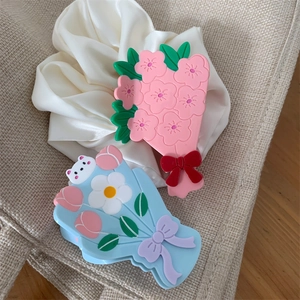 Gros plan sur des pinces à cheveux en acétate avec motifs de fleurs et de tulipes