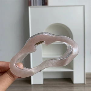 Détail d'une grande pince à cheveux ondulée en acrylique avec un fini scintillant