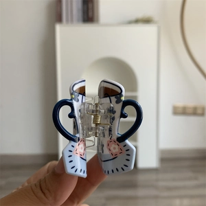Detail of floral cup shaped acrylic hair claw clip with golden metal spring for women