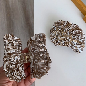 Detail of nautical-themed acetate shell hair claw clips with mosaic pattern and sturdy metal spring