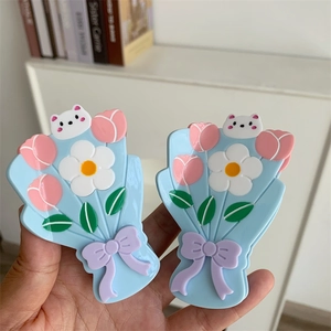 Détail de pinces à cheveux florales avec tulipes roses, marguerites et motif de chat