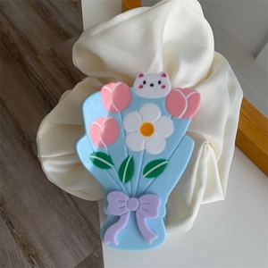Détail d'une pince à cheveux en acétate bleu avec motifs de tulipes et petit nœud