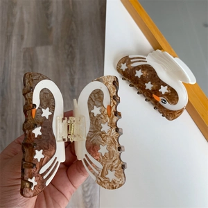 Close-up of acetic acid hair claw clip with swan design and white star patterns