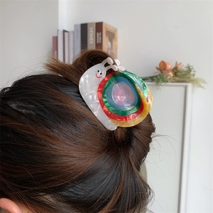 Pince à cheveux créative en acétate forme escargot avec spirale colorée sur modèle