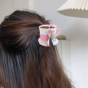 Pink floral coffee cup shaped acrylic hair claw clip worn on long brown hair