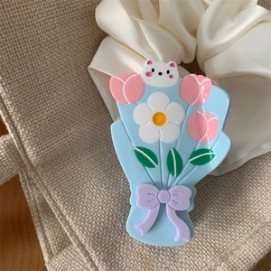 Gros plan détaillé d'une pince à cheveux florale avec un petit ours blanc et tulipes