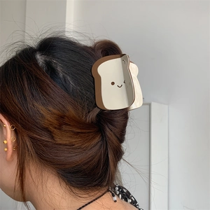 Graziosa pinza per capelli a forma di toast crema e marrone indossata da modella