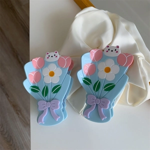 Détail de la pince à cheveux florale avec pétales bleus, tulipes roses et petit ours