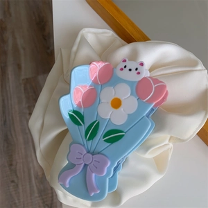 Détail d'une pince à cheveux florale en acétate avec tulipe, marguerite et petit ours