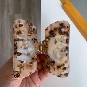 Detailed close-up of marble pattern acetate hair claw with Snoopy cartoon print