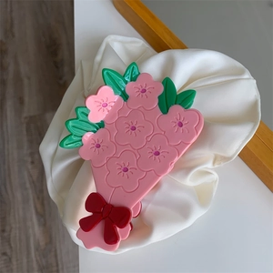 Vue détaillée de la pince à cheveux florale avec fleurs roses et nœud rouge
