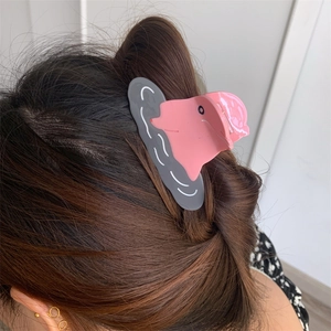 Detailed view of pink pig and grey wave acetate hair claw clip styled on brown hair