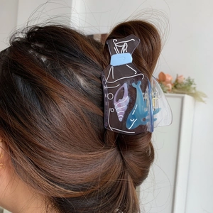 Creative blue drift bottle hair claw clip with whale and shell patterns on brown wavy hair